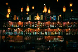 Dimly lit photo of liquor bottles on the back bar