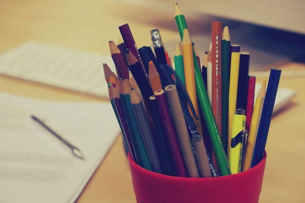 a Pencil Holder with Pencils and Pens with Resume Document on Desk