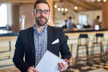 manager with pocket square and suit holding a piece of paper